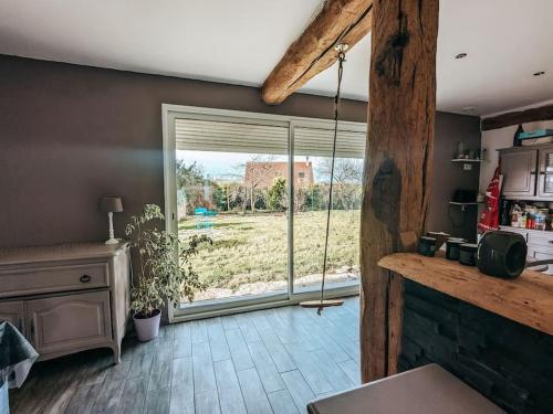 a kitchen with a large window with a view of a field at Maison avec cour et parking clos in Fère-en-Tardenois