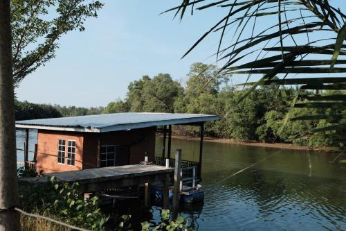 une petite maison sur un quai au bord d'une rivière dans l'établissement Qimmy Riverside Guesthouse, à Kuala Terengganu