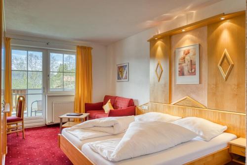 a hotel room with a bed and a chair at Hotel Alpen-Royal in Jerzens