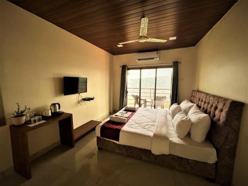 a bedroom with a large bed and a window at Trattino Resorts in Panchgani