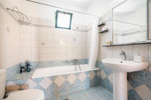 y baño con bañera, lavabo y aseo. en Villa di Lucia en Sálakos