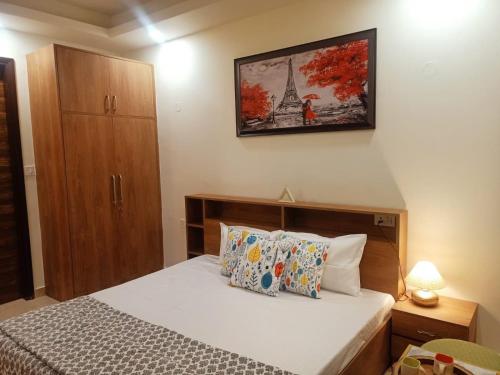 a bedroom with a bed and a picture of the eiffel tower at The Great Hansa INN in Darjeeling