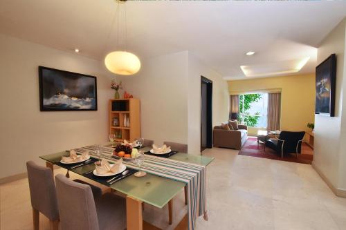 Un comedor y una sala de estar con mesa y sillas. en Somerset Berlian Jakarta, en Yakarta