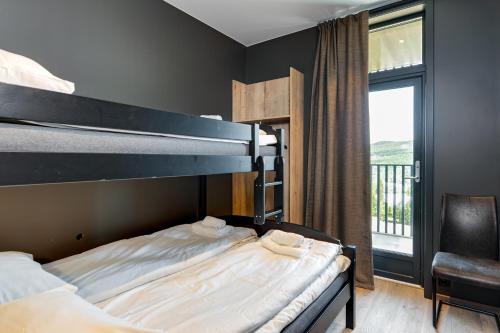 a bedroom with a bunk bed and a balcony at Trysil Alpine Lodge in Trysil