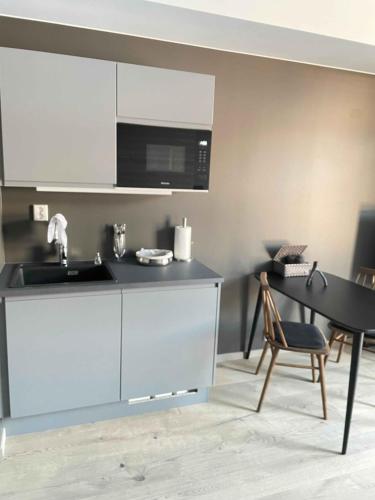 a kitchen with a sink and a microwave and a table at Trysil Alpine Lodge in Trysil