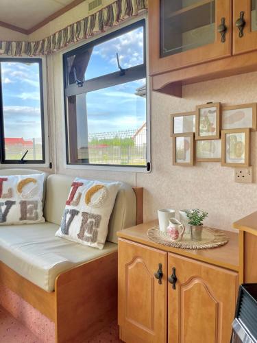 a living room with a couch and two windows at Domek holenderski in Rydzewo