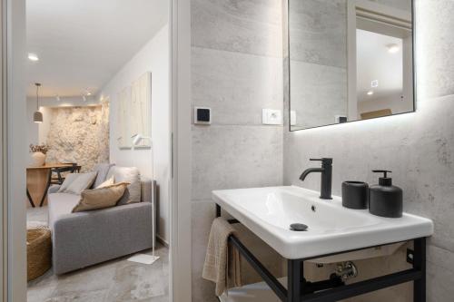baño con lavabo blanco y silla en Grotta Apartment en Vrsar
