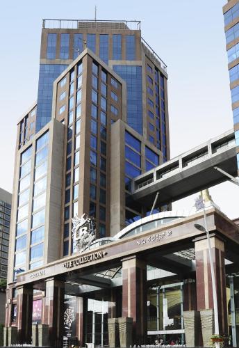 a tall building with a train station in front of it at ibis Bengaluru Hosur Road - An Accor Brand in Bengaluru