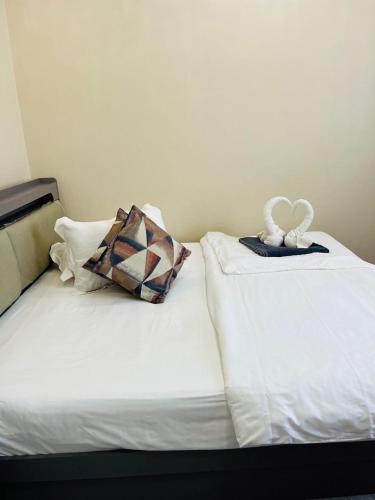 two beds with a stuffed animal on top of them at Greenlight Apartments in Kiembi Samaki