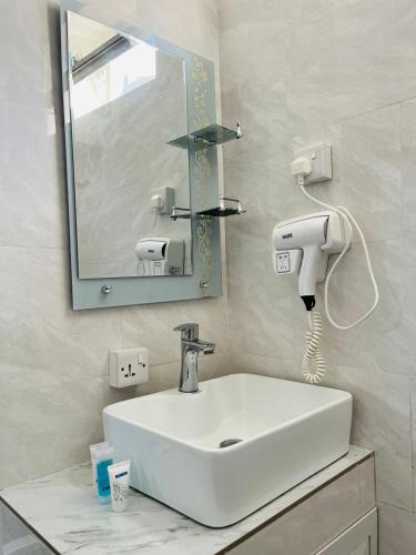 a bathroom with a white sink and a mirror at Greenlight Apartments in Kiembi Samaki