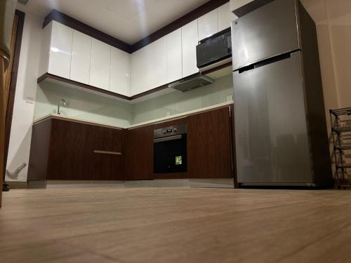 ein leeres Zimmer mit einer großen Küche und einem großen Kühlschrank in der Unterkunft غرفة مع صالة رايقة في ملنينيوم in Salalah