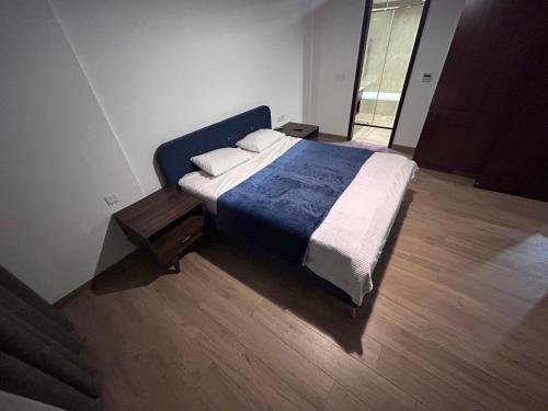 ein Schlafzimmer mit einem großen Bett mit einer blauen Decke in der Unterkunft غرفة مع صالة رايقة في ملنينيوم in Salalah