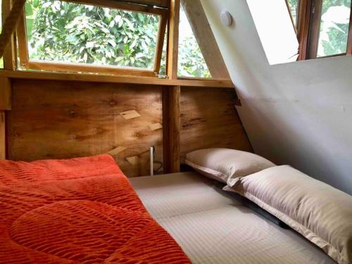 Bett in einem kleinen Zimmer mit Fenster in der Unterkunft Meru Eco Hideaway in Arusha