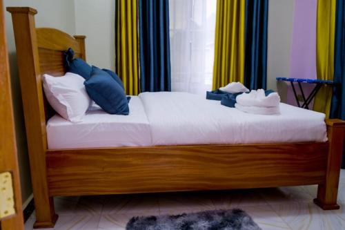 a bedroom with a wooden bed with towels on it at Grace Resort in Homa Bay