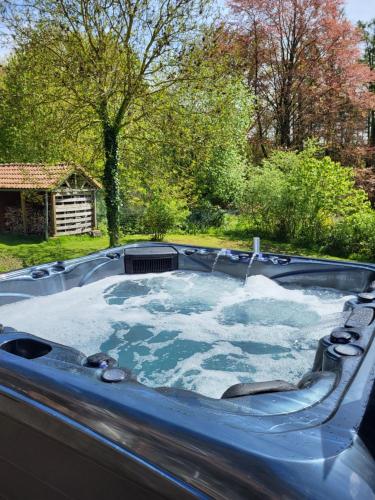 a jacuzzi tub with snow in a yard at B&B Le Bois de Champia in Huy