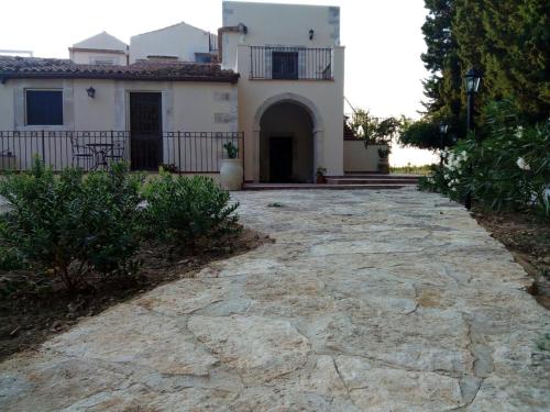 a stone driveway leading to a white house at La Chiusazza in Case Monterosso