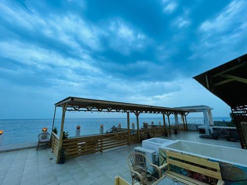 a pavilion on a beach with the ocean in the background at Club Red Dahab Motel in Dahab
