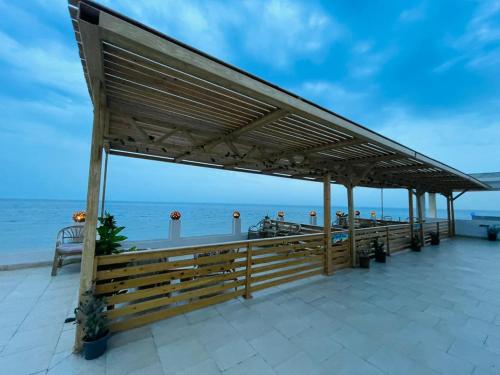 a pavilion on the beach with the ocean in the background at Club Red Dahab Motel in Dahab