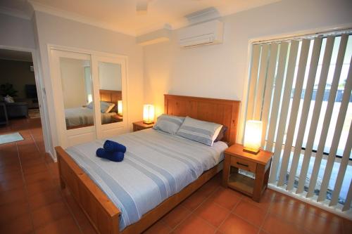 Un dormitorio con una cama con una almohada azul encima. en BankSea Holiday Home, en Agnes Water