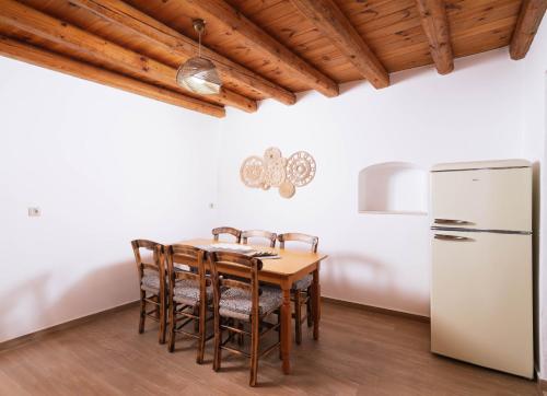 a kitchen with a wooden table and a refrigerator at Faidra House in Vóroi