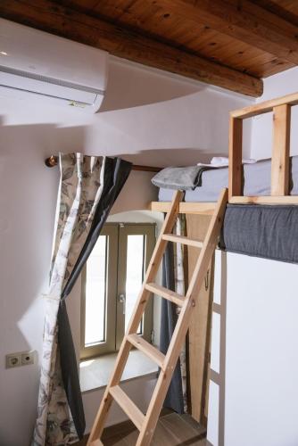 a room with two bunk beds and a ladder at Faidra House in Vóroi