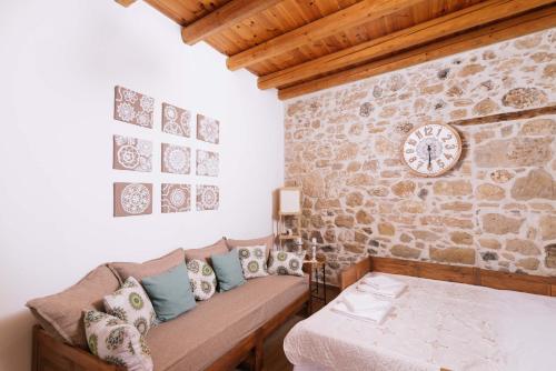 - un salon avec un canapé et une horloge murale dans l'établissement Fedra House, à Vóroi