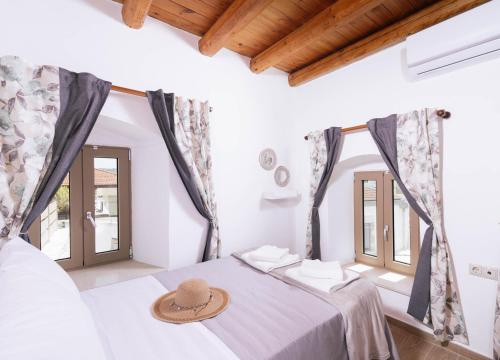 a room with a bed with a hat on it at Faidra House in Vóroi