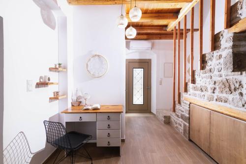 a room with a desk and chairs and a brick wall at Faidra House in Vóroi