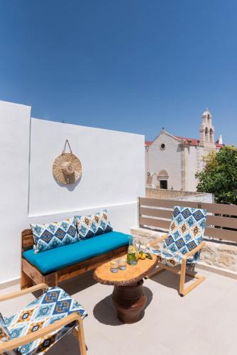 a patio with a couch and chairs and a table at Faidra House in Vóroi