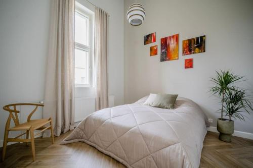1 dormitorio con 1 cama, 1 silla y 1 ventana en Loft vesinäkymällä & maksuton kadunvarsipysäköinti en Kuopio
