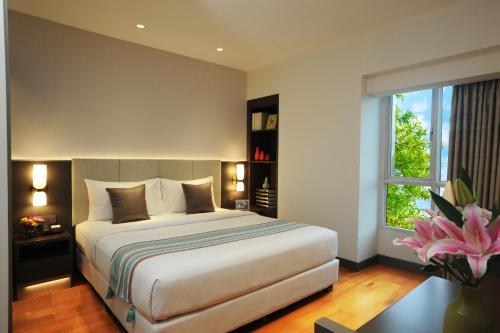 Un dormitorio con una cama grande y una ventana. en Somerset Berlian Jakarta, en Yakarta