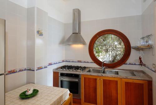 uma cozinha com um lavatório, um fogão e um espelho em Felicity: Breathtaking View On Mediterranean Sea em Maiori