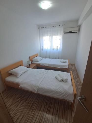 two beds in a small room with a window at Belveder Montenegro in Rafailovici