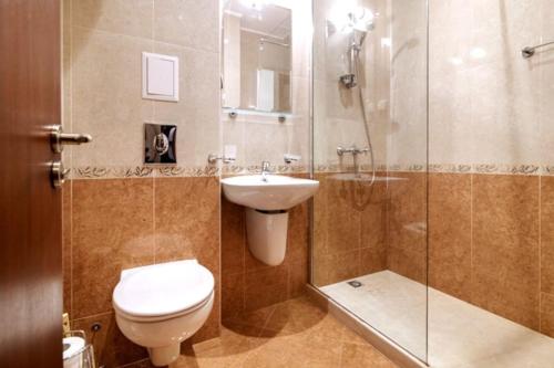 La salle de bains est pourvue de toilettes, d'un lavabo et d'une douche. dans l'établissement Cabacum Beach Residence - free parking, à Varna