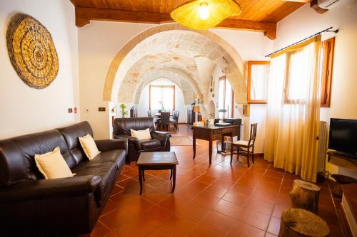 een woonkamer met lederen meubels en een boog bij B&B Villa Mamma Grazia in San Vito dei Normanni