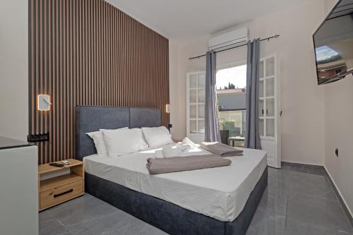 a bedroom with a large bed and a large window at Pelithea Family Aparthotel by Hotelius in Corfu Town