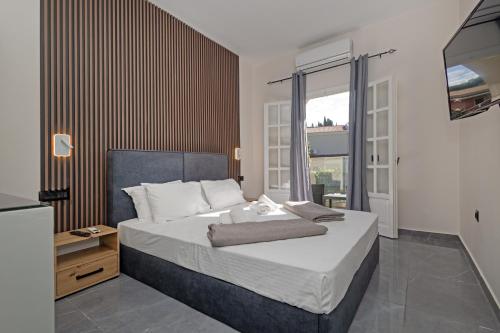a bedroom with a large bed and a large window at Pelithea Family Resort in Corfu