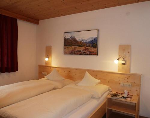 a bedroom with two beds and a table at Apart Brigitta in Sankt Leonhard im Pitztal