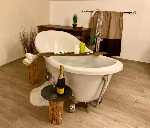 ein Badezimmer mit einer Badewanne und einer Flasche Champagner in der Unterkunft Villetta Moscal in Affi