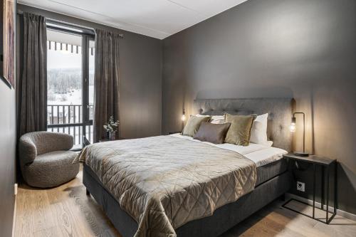 a bedroom with a bed and a chair and a window at Trysil Alpine Lodge in Trysil
