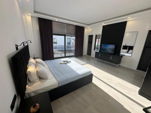 a bedroom with a large bed and a television at Belek Tatil Villa in Belek