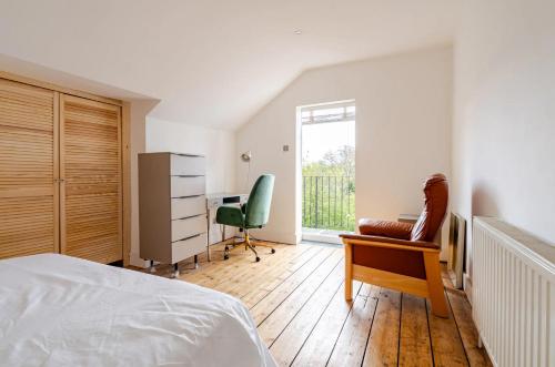 a bedroom with a bed and a desk and a chair at Blue Valley House in London