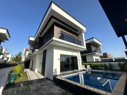a house with a swimming pool in front of it at Belek Tatil Villa in Belek