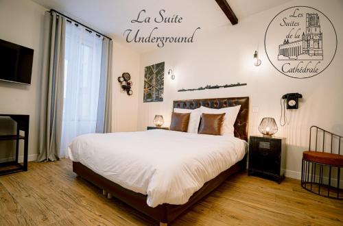 a bedroom with a bed and a sign on the wall at Les Suites de la Cathédrale in Albi