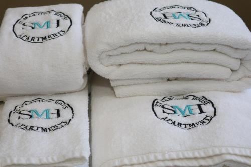 een stapel handdoeken met logo's erop bij Bridge Street Guest Rooms in Tranent