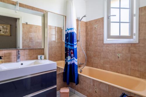 een badkamer met een wastafel en een bad bij Villa de la mer - Bretignolles in Brétignolles-sur-Mer