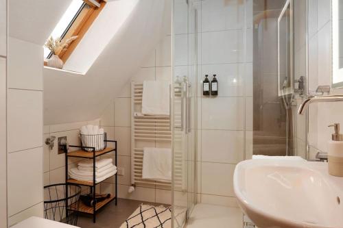 La salle de bains blanche est pourvue d'un lavabo et d'une douche. dans l'établissement Boho Apartment für 4 Wunderschöne Dachterrasse, à Eppelheim