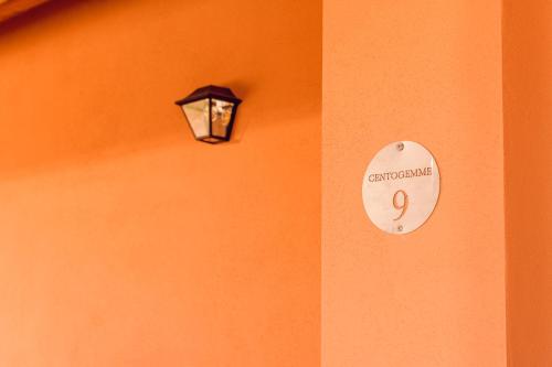 a light on a wall with a sign on it at La Vinia Bed&Wine Experience - Adults Only in Sassari