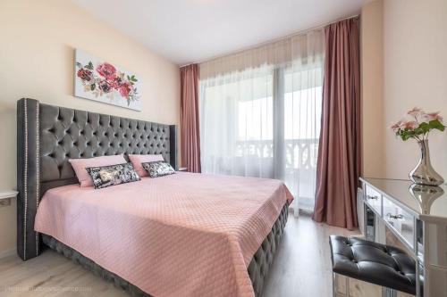 een slaapkamer met een groot bed en een raam bij Oceanview Oasis in Varna