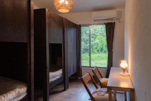 um quarto com uma mesa e cadeiras e uma janela em the Sanctuary Kohama Retreat em Kohama